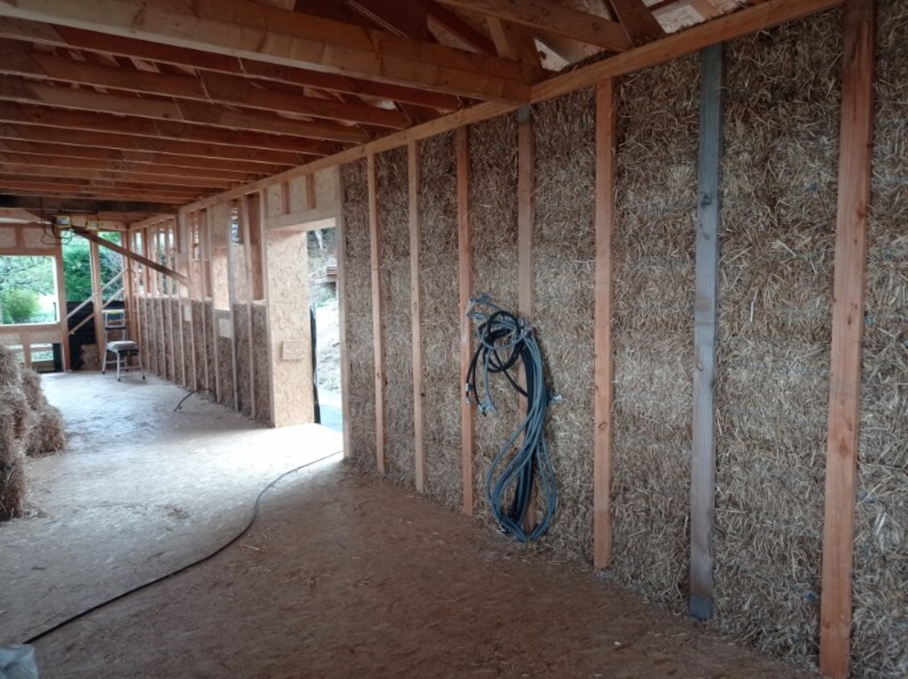 Aide à l’auto-construction sur cette maison isolée en bottes de paille